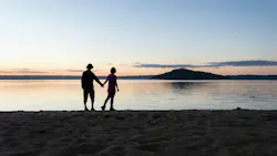 a man and a woman holding hands looking reflectively out at the water a man and a woman holding hands looking reflectively out at the water