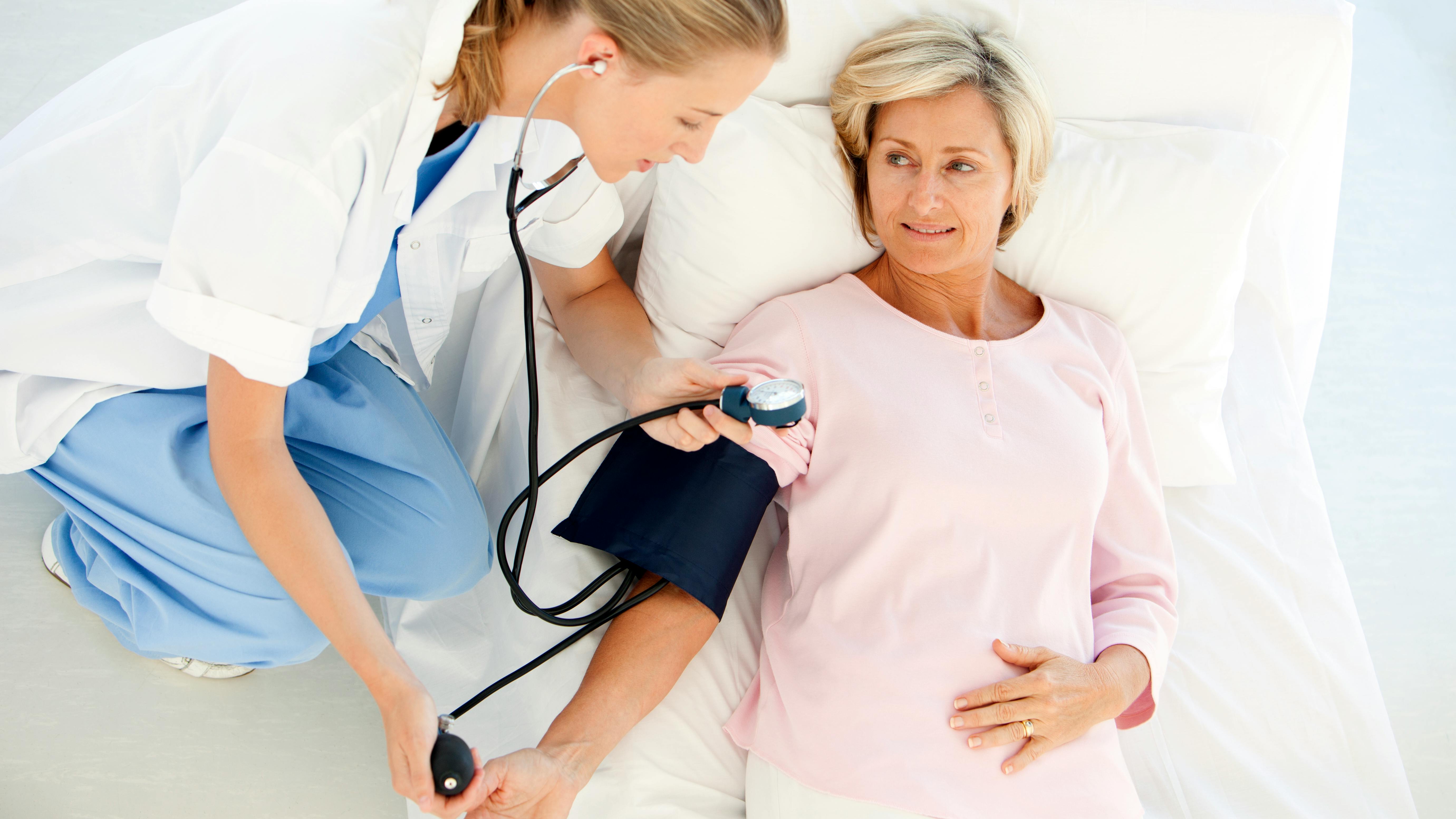 a health-care provider taking a woman's blood pressure